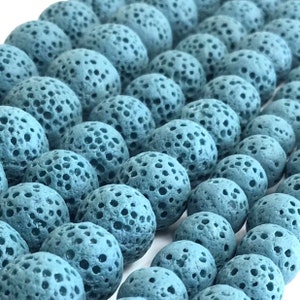 May include: A strand of blue lava rock beads. The beads are round and have a porous texture.