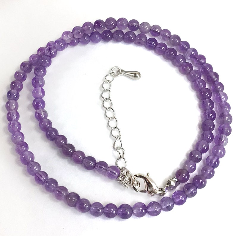 May include: A delicate amethyst gemstone necklace with a silver clasp and extender chain. The necklace is made of small, round beads and is perfect for layering.