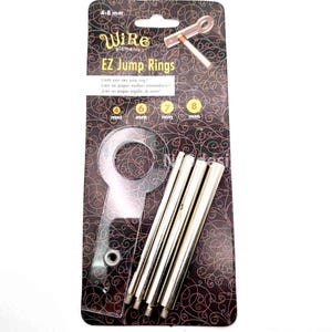 May include: A package of Wire Elements EZ Jump Rings. The package includes a clear plastic jump ring, several silver metal rods, and a copper-colored tool. The text on the package reads "Create your own jump rings!" and includes sizes from 4 mm to 8 mm.