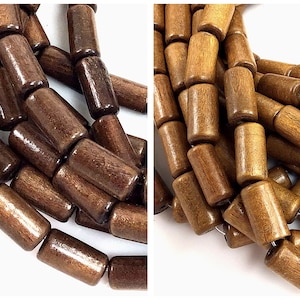 May include: Close-up of dark brown wooden beads. The beads are cylindrical with rounded ends, and appear to be strung together. The wood grain is visible, and the beads have a polished finish. The beads are a natural color and are likely used for jewelry making.