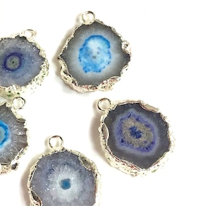 May include: Five silver-rimmed agate slice pendants with blue and purple crystal formations. The pendants have a silver loop for attaching to jewelry.