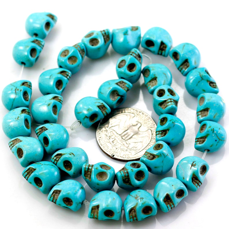 Puede incluir: Una hebra de cuentas de calavera de color azul turquesa. Las cuentas son aproximadamente del tama&ntilde;o de una moneda de 25 c&eacute;ntimos de euro.