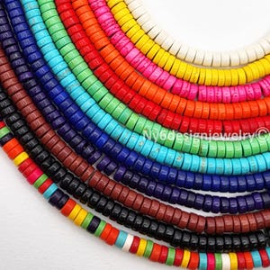 May include: A vibrant array of colorful, flat, round beads arranged in curved rows. The beads are in a rainbow of colors, including red, orange, yellow, pink, green, blue, and purple. The image is well-lit and shows the beads in detail.