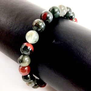 May include: A bracelet made of green, red, and black gemstone beads.