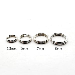 May include: Four silver-colored split rings of varying sizes are displayed against a white background. The rings are labeled with their diameters: 5.2mm, 6mm, 7mm, and 8mm. These jewelry findings are used for connecting charms and other components.