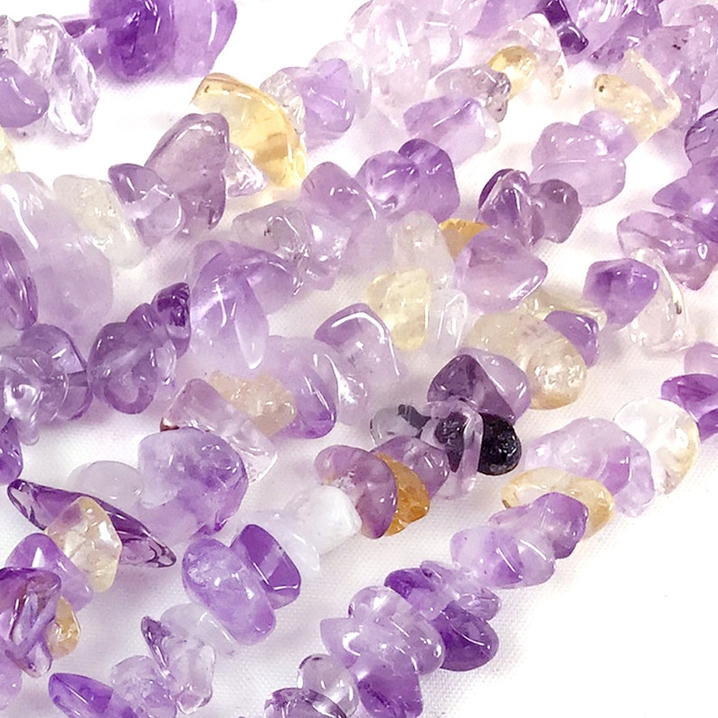 May include: A strand of purple and yellow chip gemstone beads. The beads are irregular in shape and have a natural, tumbled finish.
