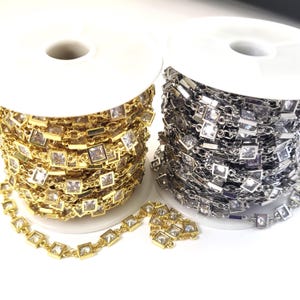 May include: Two spools of chain with square clear rhinestones. One spool is gold and the other is silver.
