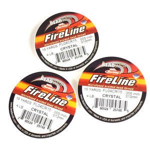 May include: Three spools of orange and black FireLine microfused braided bead thread. Each spool is labeled with the brand name Beadsmith Berkley, the product name FireLine, and the product details: 15 yards, FL04CR15, 0.005 inch, 4 lb, Crystal, 0.012 mm. The spools have a barcode and the text "www.beadsmith.com Made in USA of domestic and imported components."