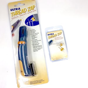 May include: A blue and yellow Ultra Thread Zap thread burner with a retractable tip. The packaging includes instructions and mentions that the product requires two AAA batteries (not included).