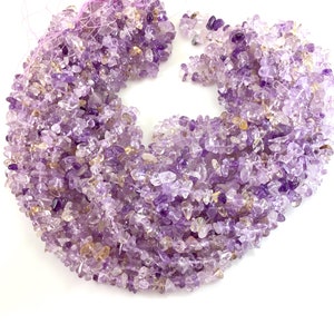 May include: A strand of amethyst chip beads, featuring a mix of light and dark purple hues. The beads are small and irregular in shape, creating a natural and rustic look.