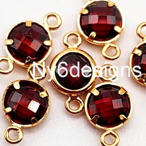 May include: Gold-toned metal connector charms with red faceted glass stones. Each charm has two loops for attaching to jewelry.
