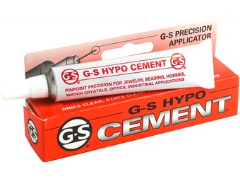May include: A red and white tube of G-S Hypo Cement with a precision applicator. The tube is labeled with the text "G-S Hypo Cement" and "Pinpoint precision for jewelry, beading, hobbies, watch crystals, optics, industrial applications. Dries clear, stays clear."