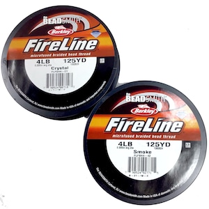 May include: Two spools of Berkley FireLine microfused braided bead thread fishing line. The spools are black with red and white text. The top spool is labeled "Crystal" and the bottom spool is labeled "Smoke". Both spools are 125 yards and 4lb test.