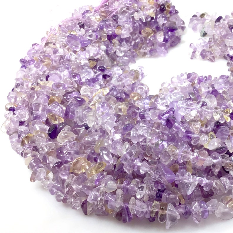 May include: A strand of small, irregular amethyst chips in shades of purple and light yellow. The chips are tumbled and polished, creating a smooth, shiny finish.