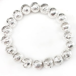 May include: A silver-colored bracelet composed of textured, spherical beads. The beads have a hammered or pitted appearance, giving them a unique, irregular surface. The bracelet is displayed against a white background.