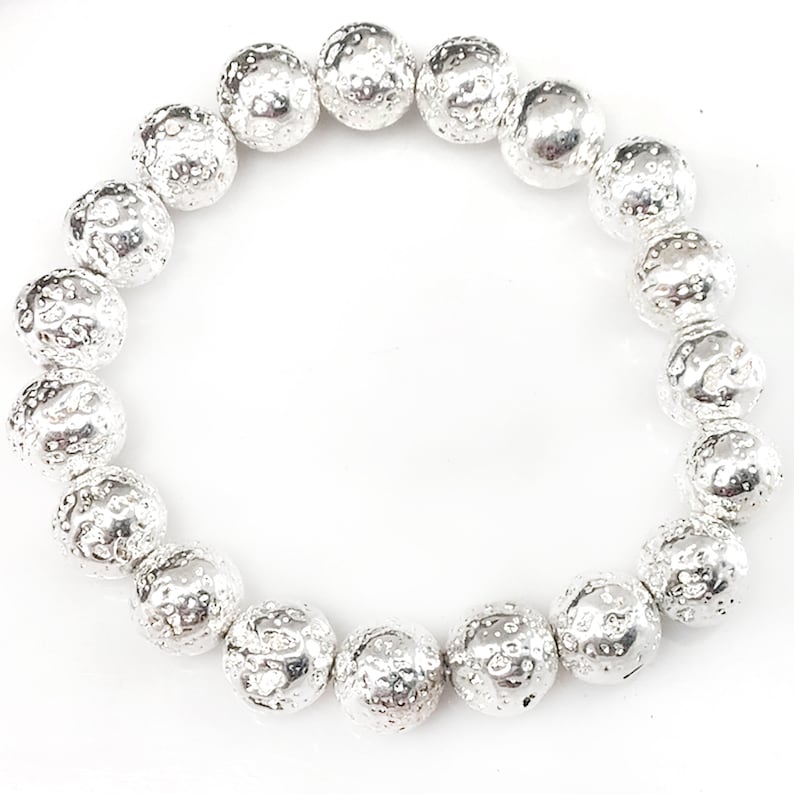 May include: A silver-colored bracelet composed of textured, spherical beads. The beads have a hammered or pitted appearance, giving them a unique, irregular surface. The bracelet is displayed against a white background.