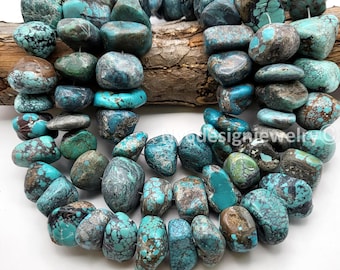 May include: Strands of turquoise gemstone beads in various shades of blue, green, and brown. The beads are irregular in shape and size, with a polished finish. The beads are strung together, ready for jewelry making.