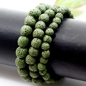 May include: A set of three green lava rock beaded bracelets. The beads are round and have a rough, porous texture.