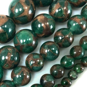 May include: A strand of round green and copper beads. The beads have a marbled effect with swirls of copper throughout the green.