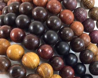 May include: A collection of wooden beads in various shades of brown, black, and purple. The beads are round and have a smooth, polished finish.