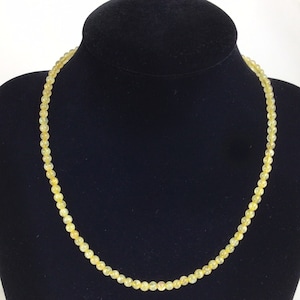 May include: A yellow citrine gemstone beaded necklace. The necklace is made of small, round beads and is approximately 18 inches long.