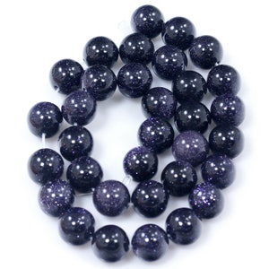 May include: A strand of dark blue round beads with a sparkly, speckled finish. The beads are strung on a clear thread.