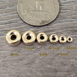 Pu&ograve; includere: Cinque chiusure magnetiche in metallo dorato di diverse dimensioni. Le chiusure sono disposte dalla pi&ugrave; grande alla pi&ugrave; piccola, con la pi&ugrave; grande che misura 8 mm di diametro e la pi&ugrave; piccola 3,2 mm di diametro.