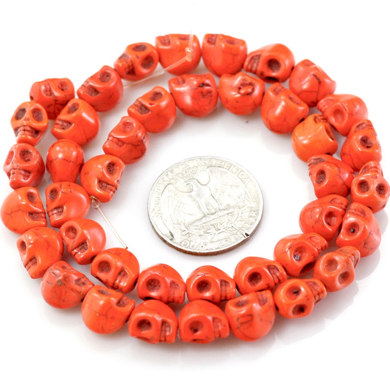 Puede incluir: Una hebra de cuentas de calavera de color naranja. Las cuentas est&aacute;n hechas de una piedra lisa y pulida. Las cuentas est&aacute;n enhebradas en un alambre delgado y tienen aproximadamente el tama&ntilde;o de una moneda de 25 centavos de d&oacute;lar estadounidense.