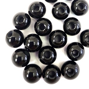 May include: A group of black round beads with a hole in the center. The beads are glossy and have a smooth surface.
