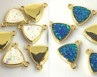 May include: Gold-tone triangle charms with a sparkly, iridescent finish. The charms have two jump rings for attaching to jewelry or other crafts. The charms are available in two colors: white and blue.