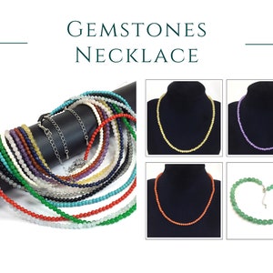 May include: A collection of gemstone necklaces in various colors, including red, green, blue, purple, and white. The necklaces are made of small, round beads and are displayed on a black background.  Gemstones Necklace.