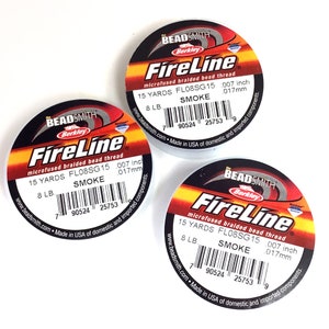 May include: Three spools of white FireLine microfused braided bead thread, each with a black and red label. The label says "FireLine", "microfused braided bead thread", "15 yards FL08SG15 .007 inch .017mm", "8 LB. SMOKE", "www.beadsmith.com. Made in USA of domestic and imported components."