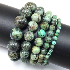 May include: A set of six turquoise gemstone bead bracelets in various sizes. The beads are a mottled green and black color.