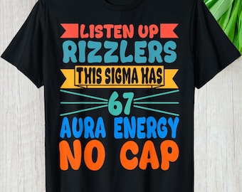 May include: Black t-shirt with a colorful graphic design. The text reads "LISTEN UP RIZZLERS THIS SIGMA HAS 67 AURA ENERGY NO CAP" in various colors including red, teal, yellow, and orange. The shirt is made of a soft material.