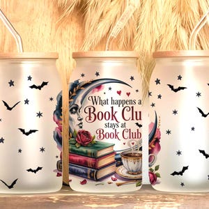 Puede incluir: Tres vasos de vidrio esmerilado con tapas de madera y pajitas. Las tazas están decoradas con murciélagos y estrellas negras. La taza central presenta el texto "What happens a Book Club stays at Book Club."