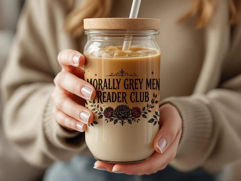 Glass jar with "Morally Grey Men Reader Club" text holding a creamy beverage with straw.