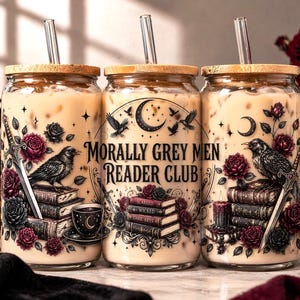 Puede incluir: Tres vasos de vidrio con tapas de madera y pajitas de vidrio, llenos de una bebida cremosa. Cada vaso presenta un dise&ntilde;o g&oacute;tico con un cuervo, rosas, una espada y el texto "Morally Grey Men Reader Club."