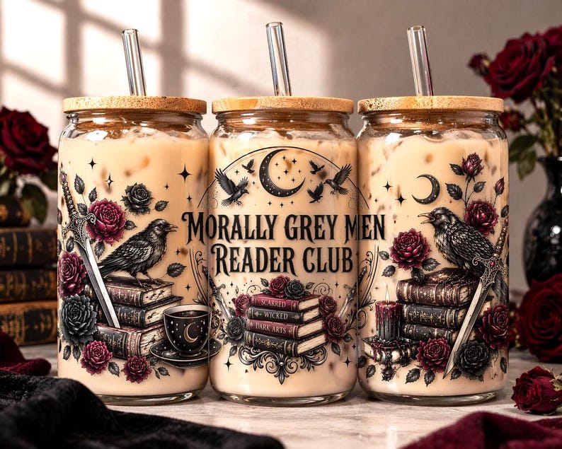 Puede incluir: Tres vasos de vidrio con tapas de madera y pajitas de vidrio, llenos de una bebida cremosa. Cada vaso presenta un dise&ntilde;o g&oacute;tico con un cuervo, rosas, una espada y el texto "Morally Grey Men Reader Club."