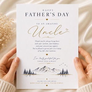 May include: A white rectangular greeting card featuring the text Happy Father's Day to an amazing Uncle in black and gold script. The card includes a mountain and forest landscape illustration at the bottom with additional text and small heart icons.
