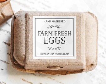 May include: A brown cardboard egg carton with a white label that reads "Hand gathered Farm Fresh Eggs Dunewind Homestead".