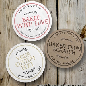 May include: Three round, white, brown, and red labels with black text. The labels have a rustic design with a floral motif. The text on the labels reads "Cinnamon Apple Pie Baked With Love From The Kitchen Of Gramma Beth", "Chocolate Chip Cookies Baked From Scratch With Love, Annaliese", and "Your Custom Text Kevin & Jessica - 6.19.25".
