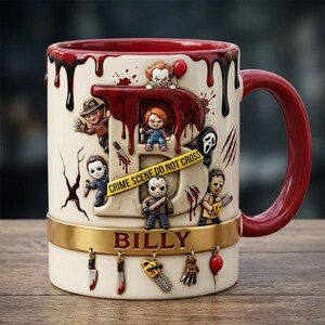 May include: A ceramic mug with a red interior and handle, featuring horror movie characters and the name "BILLY." The mug has a white base with a gold band and decorative charms. The letter "B" is filled with red, dripping blood, and the words "CRIME SCENE DO NOT CROSS" are printed on a yellow tape.