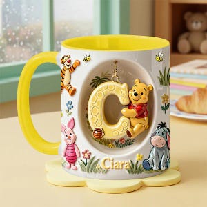 May include: A Winnie the Pooh themed mug with a yellow handle and interior. The mug features the letter "C" with Pooh Bear, Tigger, Piglet, and Eeyore. The name "Ciara" is written on the mug.