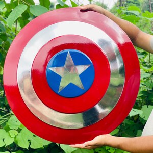 May include: A round shield in red, white, and blue, featuring a silver star at its centre. The shield has a glossy finish. It is a replica of Captain America's shield.