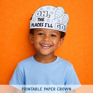 Op de afbeelding: Een lachend kind draagt een witte papieren kroon met de tekst "Oh, the places I'll go!" en ster- en ballonillustraties. Het kind draagt een lichtblauw t-shirt tegen een oranje achtergrond. De tekst "Printable Paper Crown" staat onderaan.