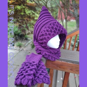 May include: Purple crocheted hooded cowl and fingerless gloves with a scale pattern. The text "IT'S IN THE BAG CROCHET" is visible on the left side of the image.