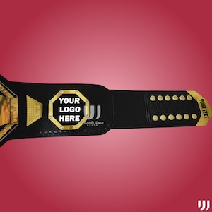 May include: Black and gold championship belt with the text "YOUR LOGO HERE" in a gold octagon. The belt has gold accents and the text "YOUR TEXT" on the end. The brand name "Unicoish Wear BELTS" is also visible.