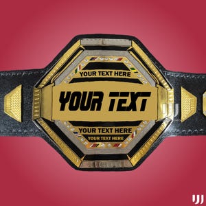 May include: A black and gold championship belt with the text "YOUR TEXT" in bold, black letters. The belt has a large central plate and smaller side plates, all with gold accents and decorative elements. The text "YOUR TEXT HERE" is also visible.