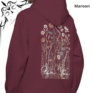 May include: Maroon hoodie with a floral design on the back. The design features various flowers and foliage in shades of beige, orange, and white. The words "For You" are written in a cursive font below the floral arrangement.