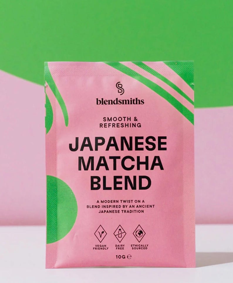 May include: A pink packet of Japanese Matcha Blend by blendsmiths, with green accents. The text on the packet reads "Smooth & Refreshing" and "A modern twist on a blend inspired by an ancient Japanese tradition." The packet is vegan friendly, dairy free, and ethically sourced.